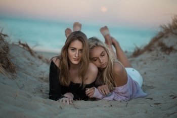 two women lying on beach 